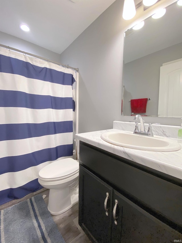 bathroom with vanity, hardwood / wood-style flooring, and toilet