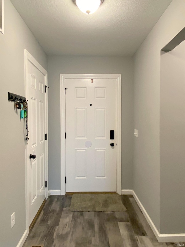 entryway featuring dark hardwood / wood-style flooring and a textured ceiling