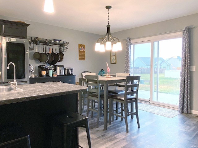 dining space featuring sink, a chandelier, and hardwood / wood-style flooring