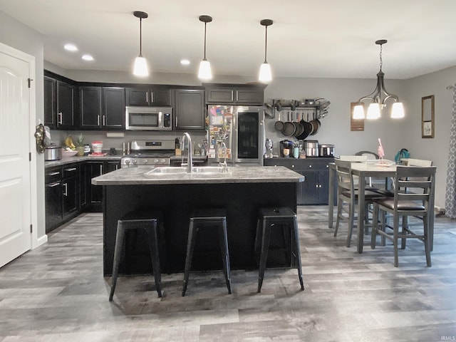 kitchen featuring a center island with sink, pendant lighting, and stainless steel appliances