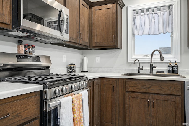 kitchen with sink, dark brown cabinets, and appliances with stainless steel finishes