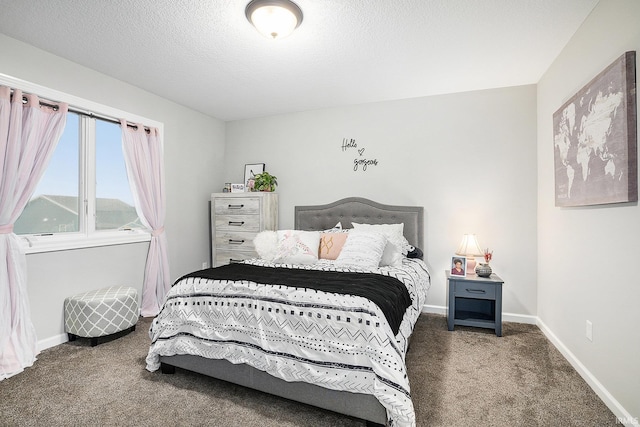 bedroom featuring a textured ceiling and dark colored carpet