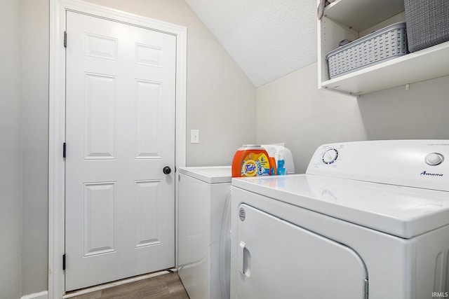 clothes washing area with washer and clothes dryer and dark hardwood / wood-style flooring