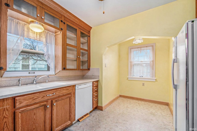 kitchen with a wealth of natural light, stainless steel fridge, dishwasher, and sink