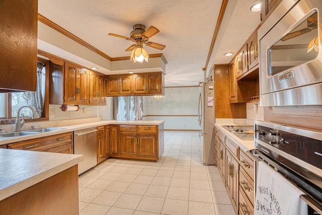 kitchen featuring crown molding, sink, ceiling fan, a textured ceiling, and appliances with stainless steel finishes