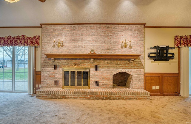 living room featuring a fireplace, a textured ceiling, carpet flooring, and crown molding