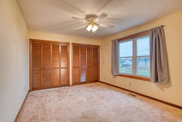 unfurnished bedroom featuring a textured ceiling, carpet floors, and ceiling fan