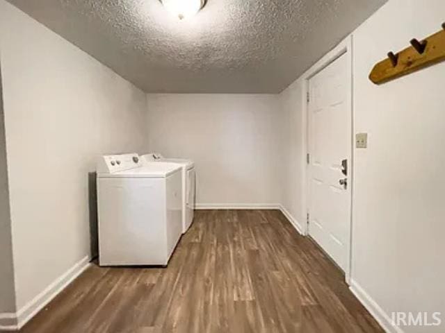 clothes washing area with dark wood-type flooring, a textured ceiling, and independent washer and dryer