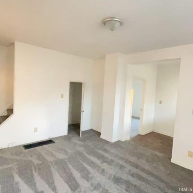 unfurnished room with dark colored carpet