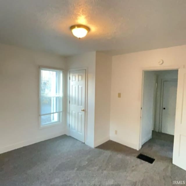 carpeted spare room with a textured ceiling