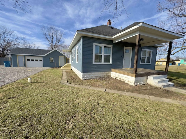 bungalow-style home featuring an outbuilding, a garage, and a front lawn