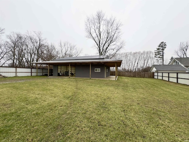 rear view of house featuring a lawn and an outbuilding