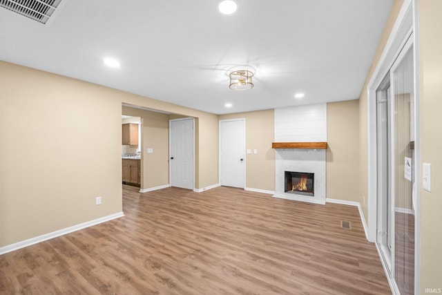 unfurnished living room featuring hardwood / wood-style flooring and a fireplace