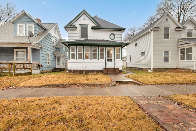 view of front facade with a sunroom and a front yard