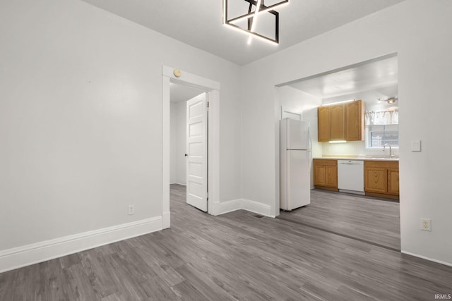 unfurnished living room with hardwood / wood-style floors and sink