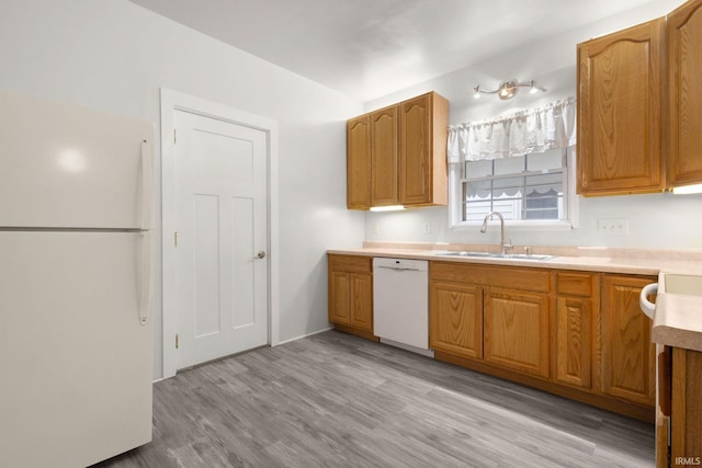 kitchen with sink, white appliances, and light hardwood / wood-style flooring