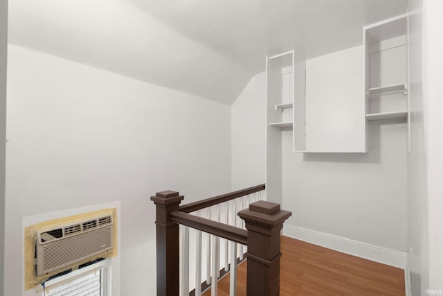 stairs featuring an AC wall unit and hardwood / wood-style floors