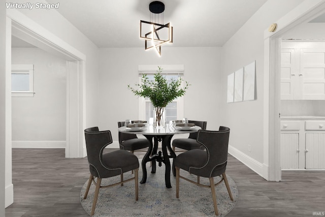 dining space featuring an inviting chandelier, plenty of natural light, and dark wood-type flooring