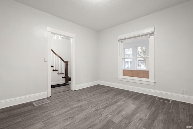 spare room featuring a textured ceiling and dark wood-type flooring