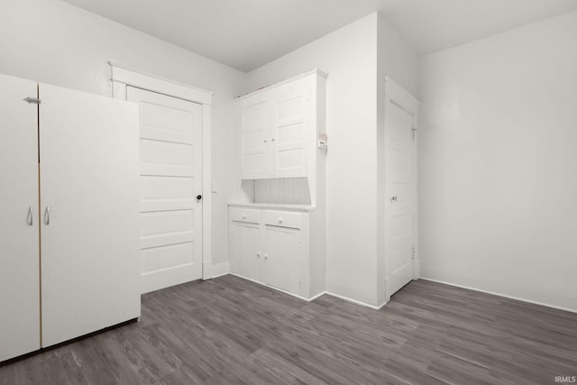 unfurnished bedroom featuring dark hardwood / wood-style flooring and a closet