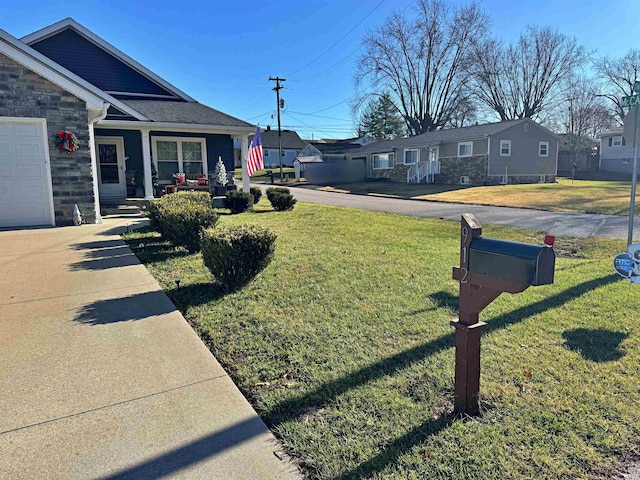 view of side of home with covered porch, a garage, and a yard