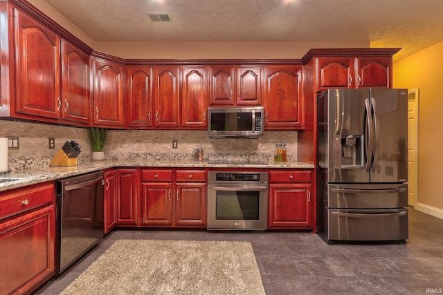 kitchen featuring light stone countertops, a textured ceiling, backsplash, and stainless steel appliances