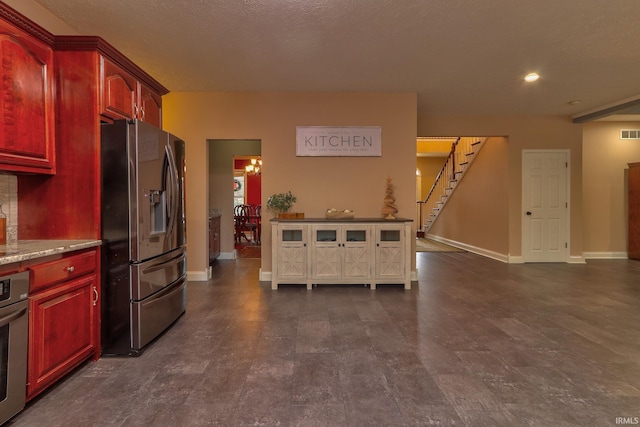 394 W Evergreen Plz, Santa Claus, IN 47579 - kitchen featuring stainless steel refrigerator with ice dispenser, reddish brown cabinets, and light stone countertops