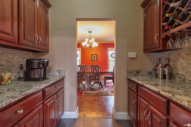 kitchen featuring decorative backsplash, crown molding, dark hardwood / wood-style floors, and a notable chandelier