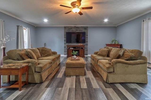 living room with a stone fireplace, crown molding, and dark hardwood / wood-style flooring