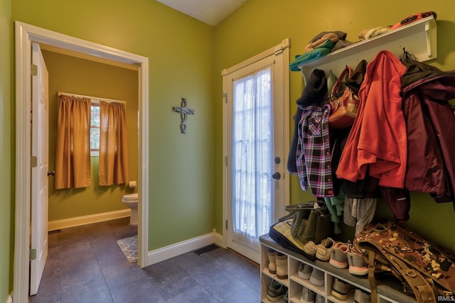 mudroom with dark tile patterned flooring and a healthy amount of sunlight