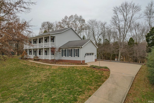 view of front of property featuring a balcony, a front lawn, covered porch, and a garage