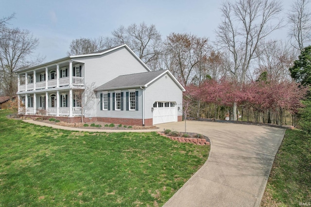 394 W Evergreen Plz, Santa Claus, IN 47579 - view of front of house with a porch, a balcony, concrete driveway, a front lawn, and a garage