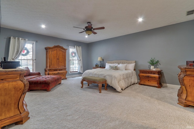 carpeted bedroom with multiple windows, ceiling fan, and a textured ceiling