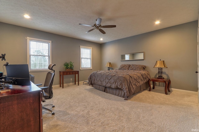 carpeted bedroom featuring ceiling fan and a textured ceiling