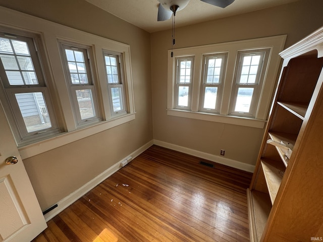 spare room with dark hardwood / wood-style flooring and ceiling fan