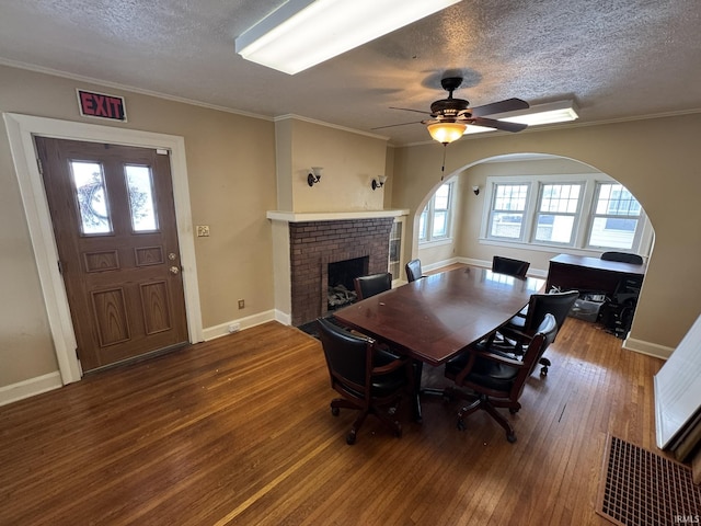 dining area featuring a fireplace, hardwood / wood-style floors, a wealth of natural light, and ornamental molding