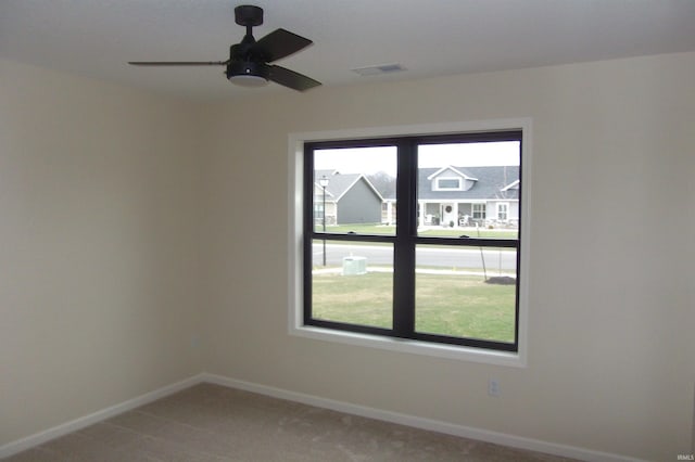 spare room with carpet floors, plenty of natural light, and ceiling fan