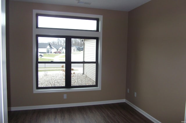 empty room with dark hardwood / wood-style flooring