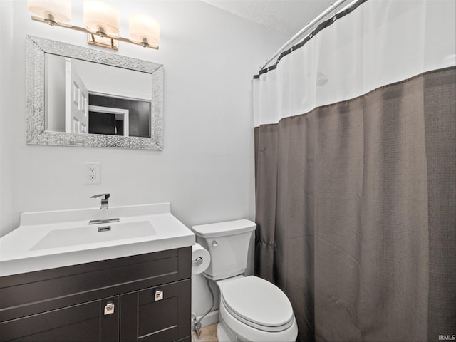 bathroom with vanity, toilet, and a textured ceiling