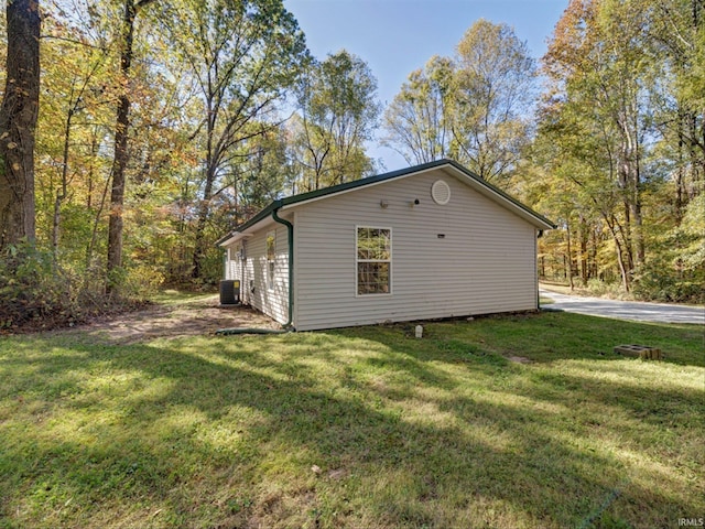 view of side of property featuring cooling unit and a lawn