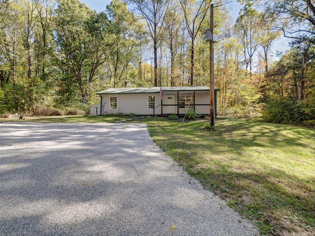 view of front of house with a front lawn and a storage shed