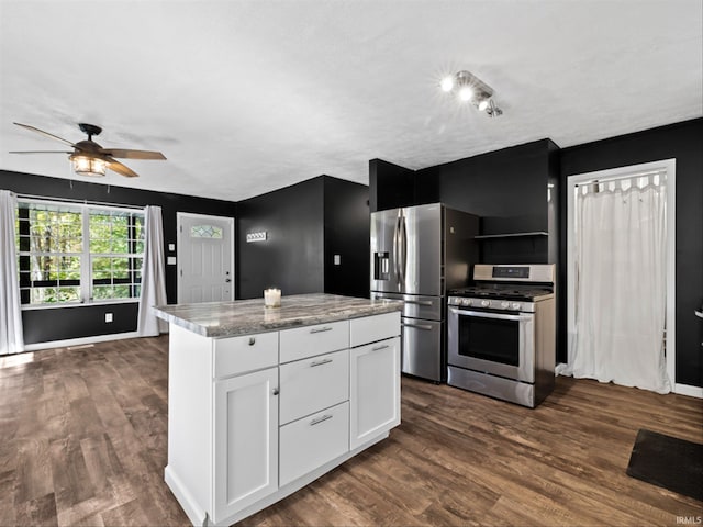 kitchen featuring light stone countertops, appliances with stainless steel finishes, dark hardwood / wood-style flooring, ceiling fan, and white cabinets