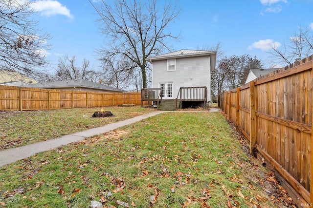 back of property with a deck and a lawn