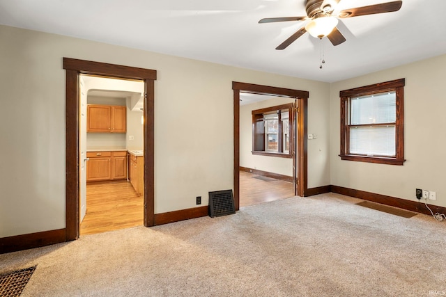 unfurnished room with ceiling fan and light colored carpet