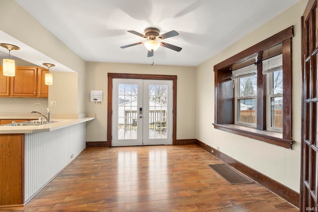 interior space with plenty of natural light, wood-type flooring, sink, and french doors