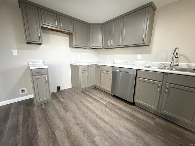 kitchen featuring dishwasher, dark wood-type flooring, gray cabinetry, and sink