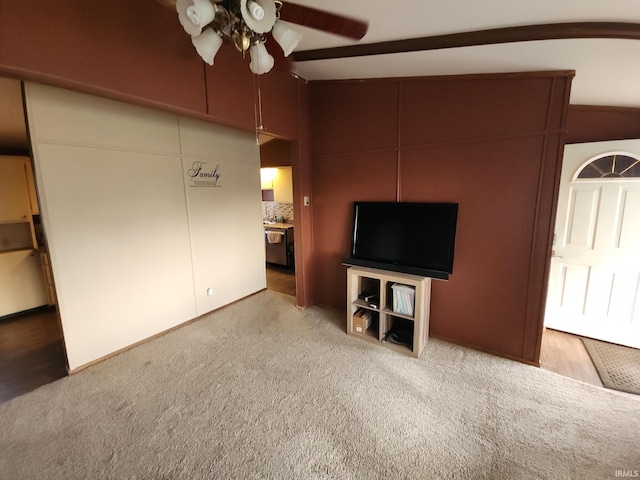 unfurnished living room with ceiling fan, light colored carpet, and vaulted ceiling