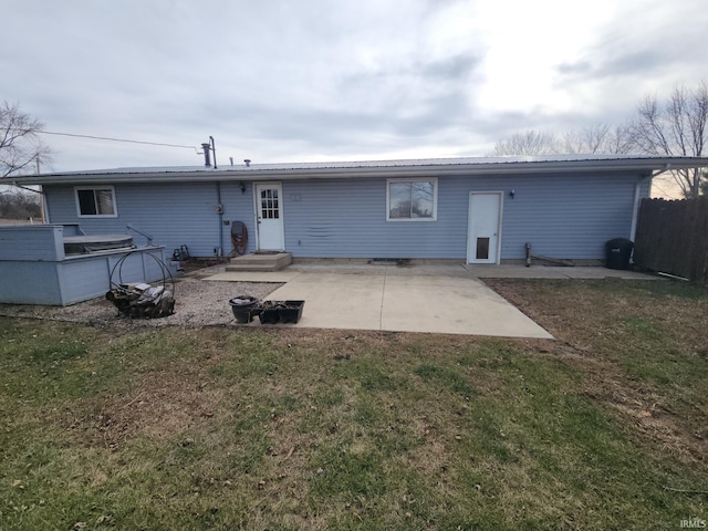 back of property with a lawn and a patio