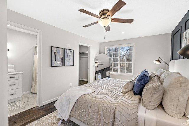 bedroom featuring ceiling fan, a walk in closet, dark wood-type flooring, and a closet