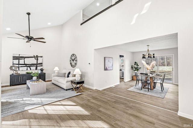 living room with wood-type flooring, high vaulted ceiling, and ceiling fan